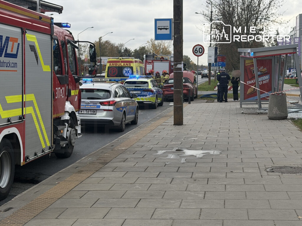 Straż pożarna, karetka i radiowozy stoją na ulicy przy przystanku autobusowym, a policjanci zabezpieczają miejsce zdarzenia.
