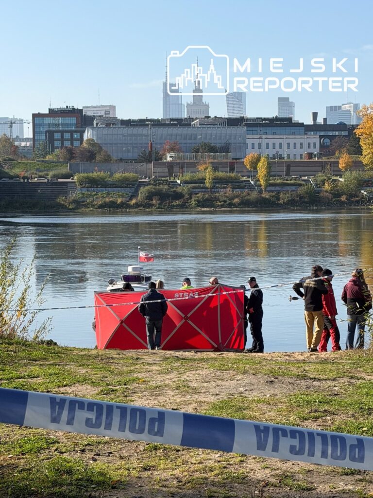 Służby ratunkowe zabezpieczają miejsce nad Wisłą czerwoną osłoną, a na brzegu leży taśma policyjna.